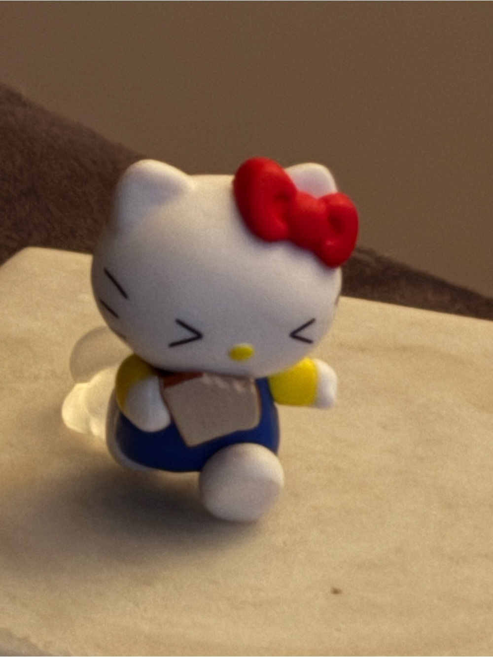 Hello Kitty Figurine with Red Bow and Blue Outfit Running Dust Cloud